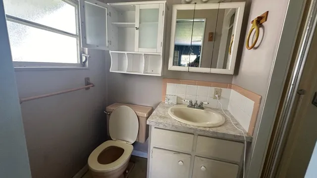 a bathroom with a toilet sink and mirror