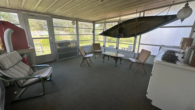 a living room with furniture a flat screen tv and a large window