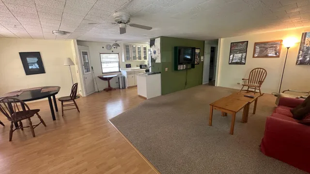 a living room with furniture a dining table and paintings on the wall