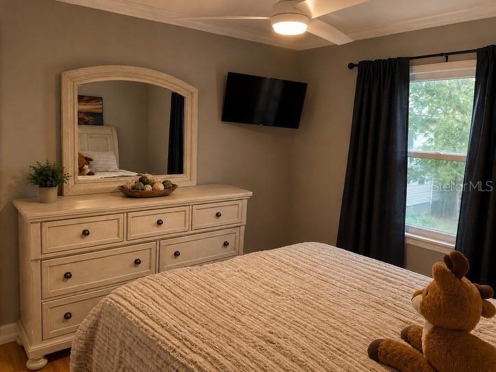 1623 Wavecrest Street Merritt Island, FL 32952 - Photo 18 of 26 a bedroom with a bed and a flat tv screen on dresser