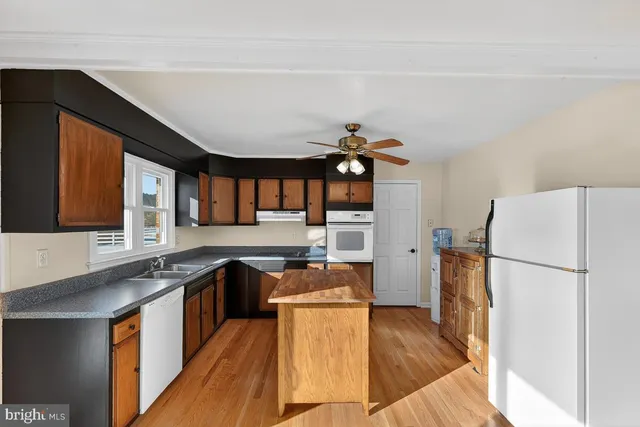 a kitchen with granite countertop a sink a counter top space and stainless steel appliances