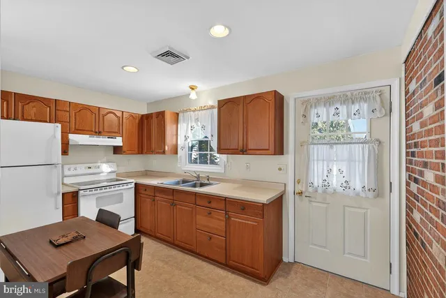 a living room with stainless steel appliances kitchen island granite countertop furniture and a refrigerator