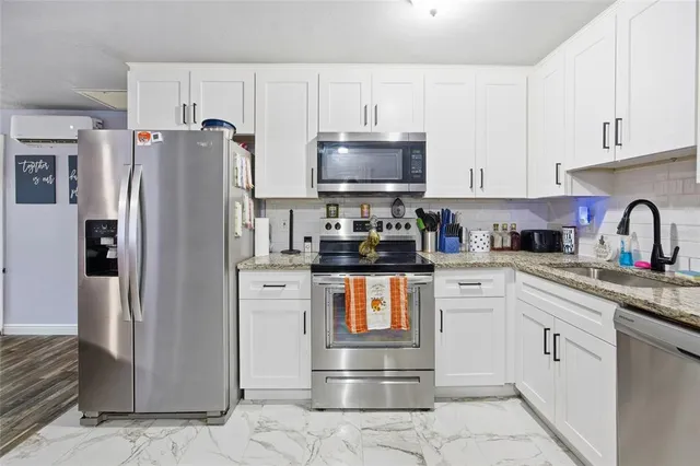 a kitchen with stainless steel appliances a refrigerator sink and cabinets