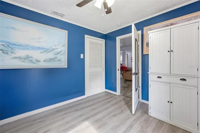 a view of a hallway with wooden floor and closet