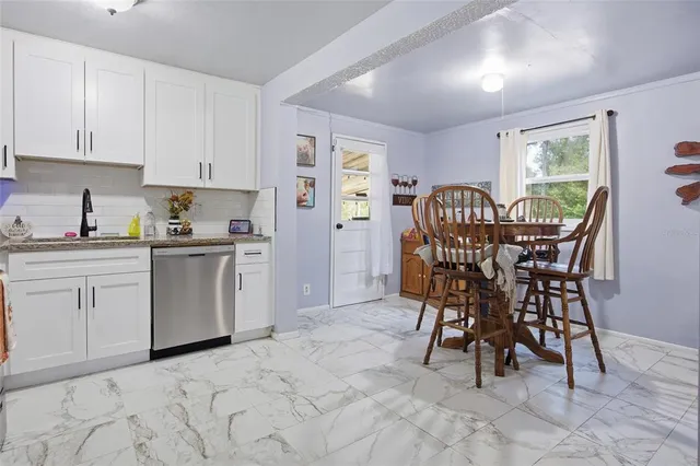 a kitchen with a table chairs sink and cabinets