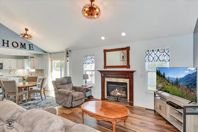 a living room with furniture a flat screen tv and a fireplace