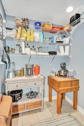 a utility room with stainless steel appliances furniture and a wooden floor