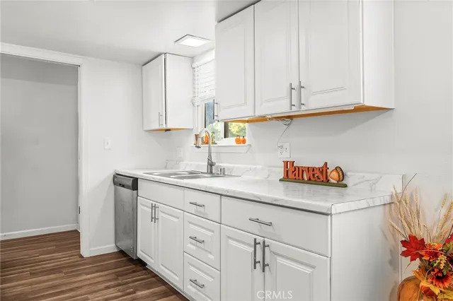 a kitchen with white cabinets and sink