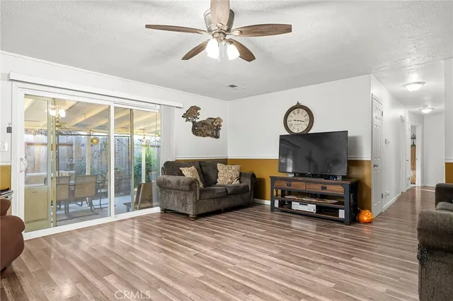 a living room with furniture a flat screen tv and a large window