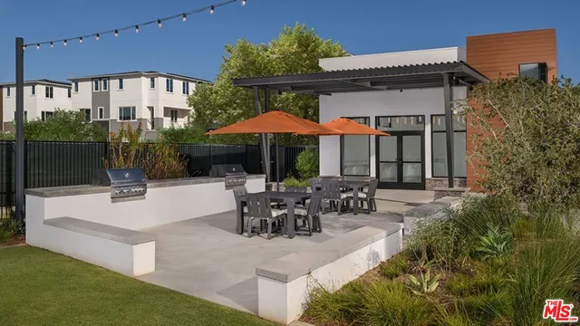 a view of a patio with couches table and chairs under an umbrella