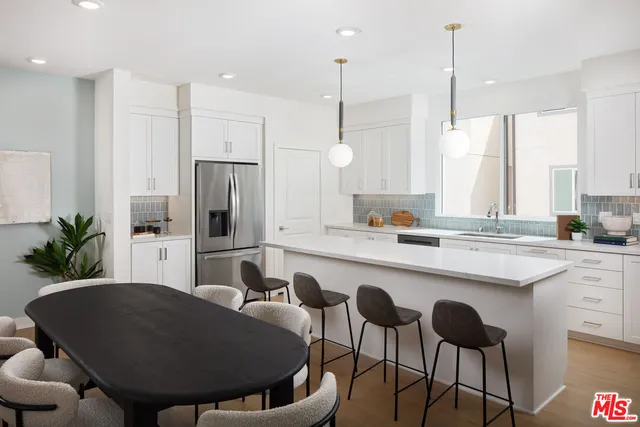 a kitchen with a table chairs sink and cabinets