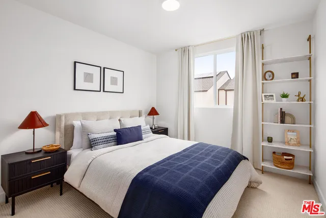 a bedroom with a bed and a lamp with the dresser