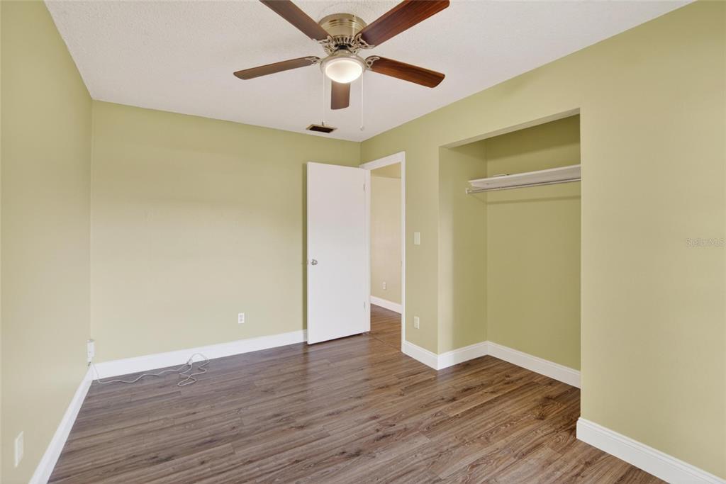 2340 Merrily Circle South Seffner, FL 33584 - Photo 24 of 52 an empty room with wooden floor and a ceiling fan