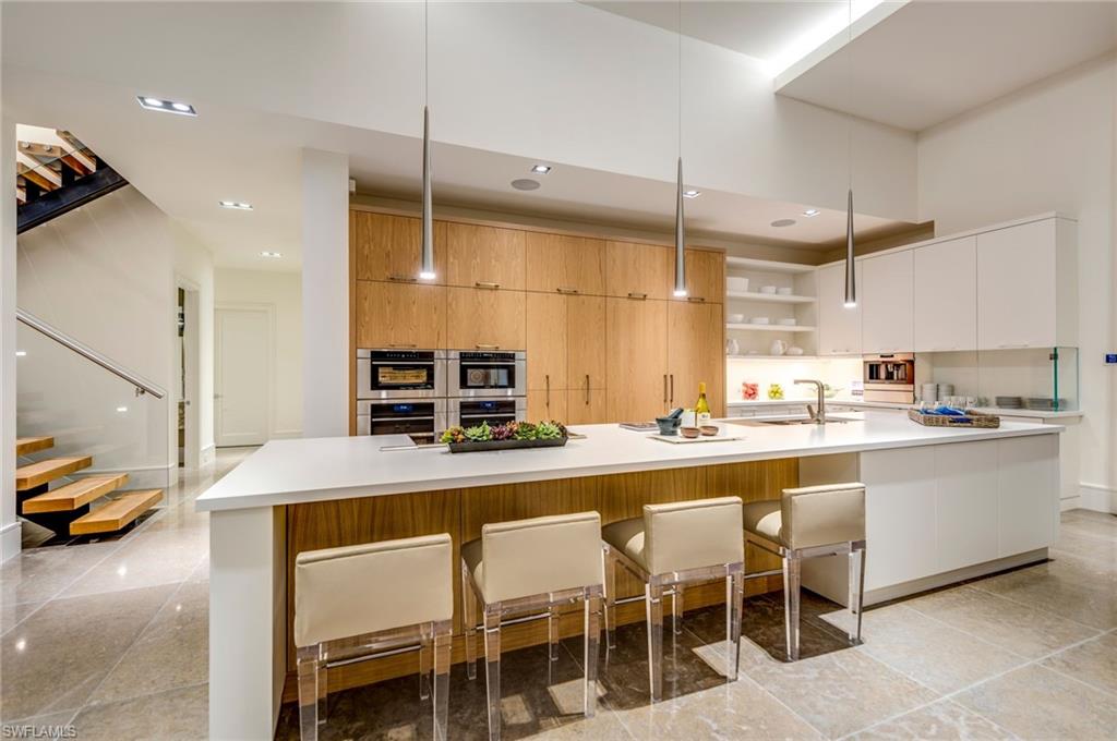 2175 Crayton Road Naples, FL 34103 - Photo 13 of 34 a kitchen with counter and chairs