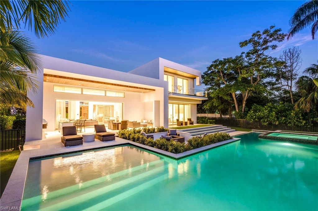 2175 Crayton Road Naples, FL 34103 - Photo 2 of 34 a view of a house with swimming pool and sitting area