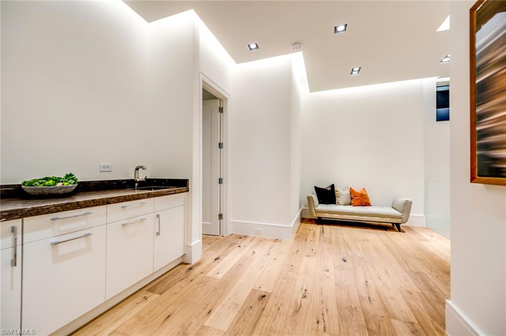 2175 Crayton Road Naples, FL 34103 - Photo 25 of 34 a hallway with cabinets and wooden floor