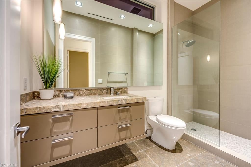 2175 Crayton Road Naples, FL 34103 - Photo 27 of 34 a bathroom with a granite countertop sink toilet and shower