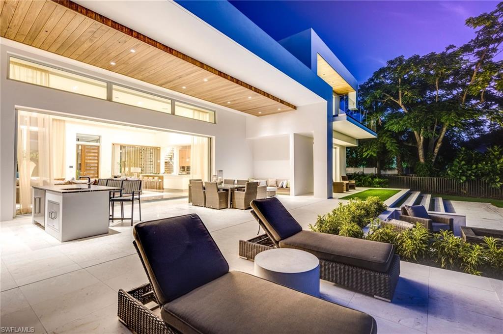 2175 Crayton Road Naples, FL 34103 - Photo 4 of 34 a view of a patio with couches table and chairs and potted plants