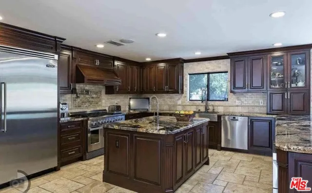 a kitchen with stainless steel appliances granite countertop a stove and a sink