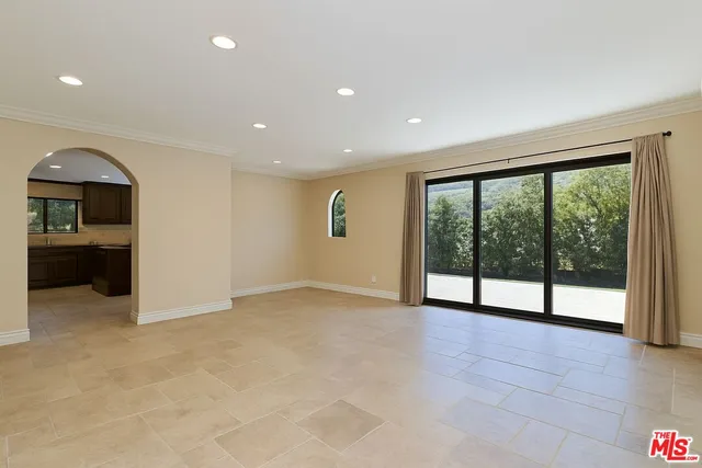 a view of a livingroom with an empty space and a refrigerator a fireplace