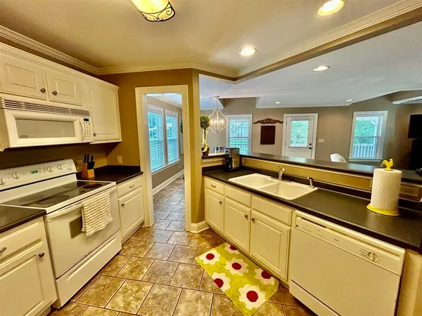 a large kitchen with stainless steel appliances granite countertop a sink and cabinets