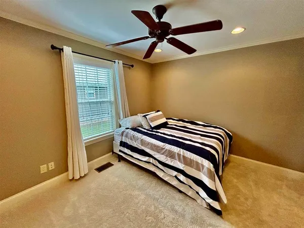 a bedroom with a bed and a ceiling fan