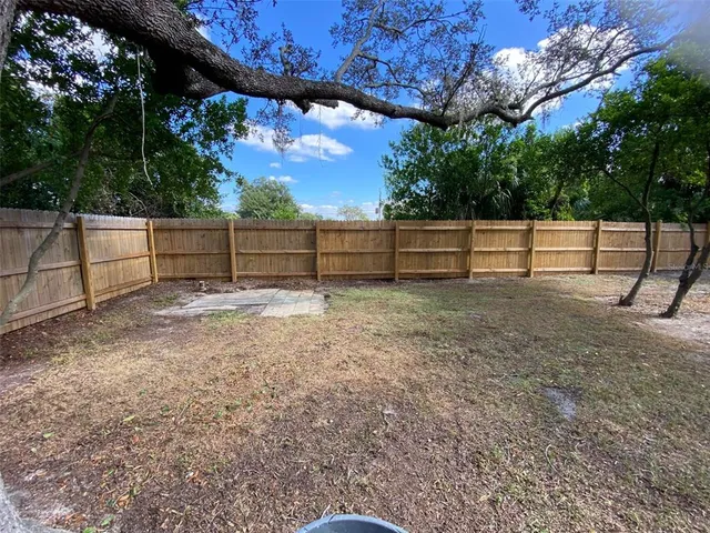 a view of backyard with wooden fence