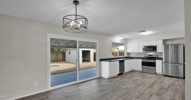 a kitchen with stainless steel appliances granite countertop a refrigerator a stove top oven a sink and dishwasher