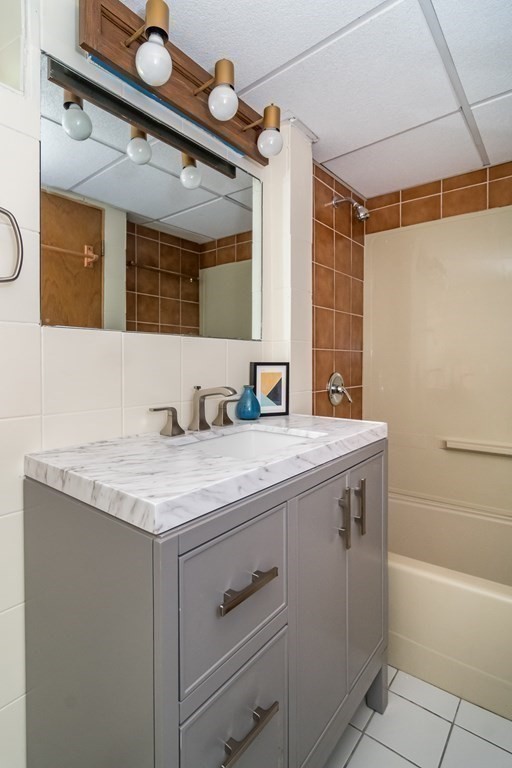 10 Winch Way Natick, MA 01760 - Photo 26 of 34 a bathroom with a granite countertop sink a mirror and a bathtub