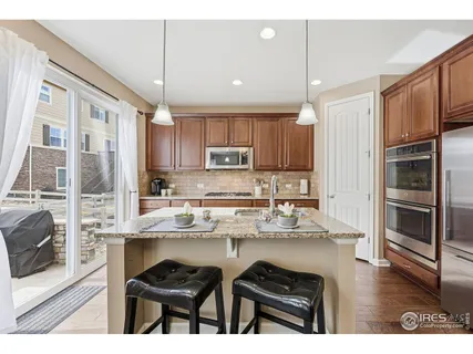 a kitchen with stainless steel appliances granite countertop a refrigerator and a stove top oven