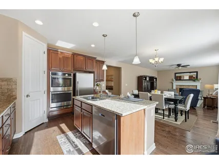 a kitchen with stainless steel appliances kitchen island granite countertop a sink stove and refrigerator
