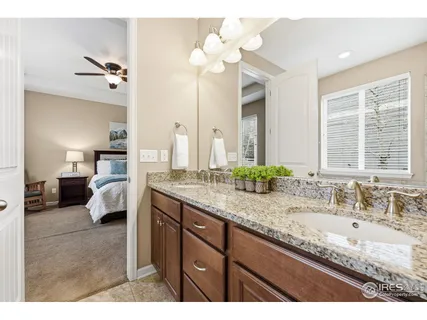 a en suite bathroom with a granite countertop sink and a mirror