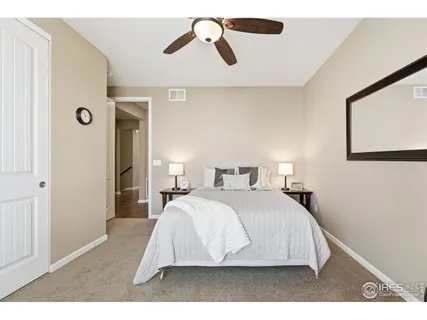 a bedroom with a bed and painting on the wall