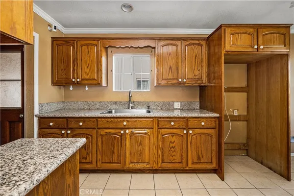 a kitchen with granite countertop a sink and cabinets