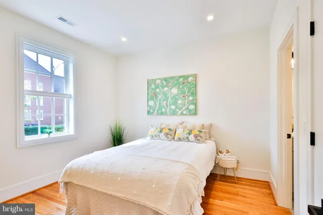 a bedroom with a bed and a painting on the wall