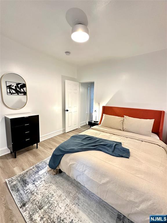 48 Maple Avenue, Unit 2 Montclair, NJ 07042 - Photo 5 of 7 a bedroom with a large bed and a chandelier