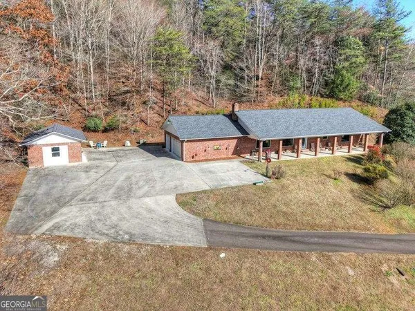 a view of a house with a yard and large tree