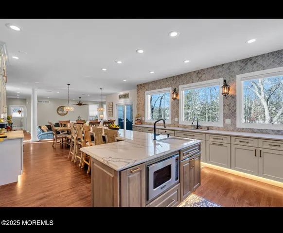 a kitchen with a stove a counter top space and living room view