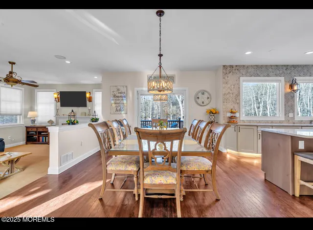 a dining room with furniture a chandelier and wooden floor