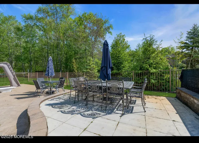 a view of a patio with table and chairs potted plants and palm tree