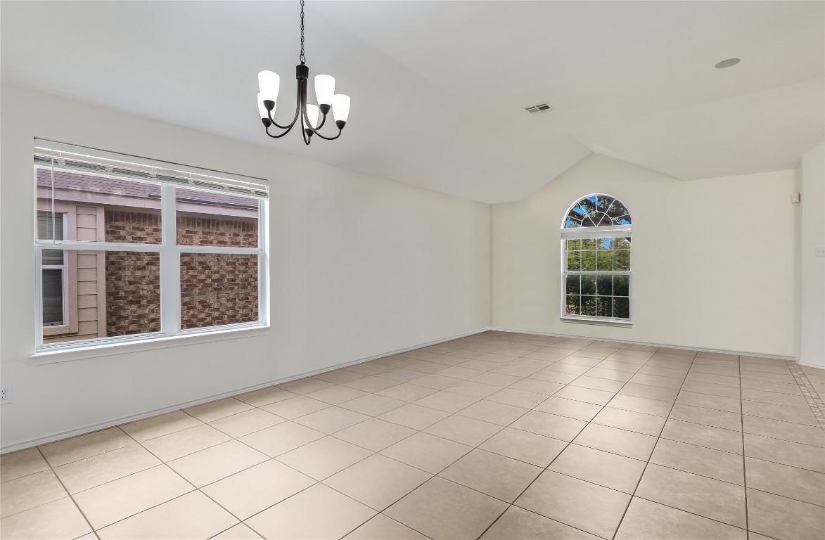 1901 Rachel Lane Round Rock, TX 78664 - Photo 12 of 35 Spare room with vaulted ceiling, a chandelier, light tile patterned floors, and baseboards