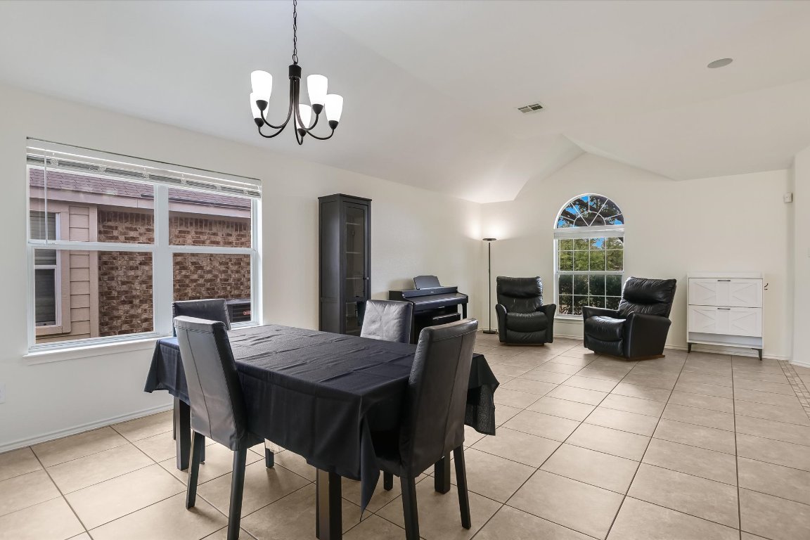 1901 Rachel Lane Round Rock, TX 78664 - Photo 13 of 35 Dining room featuring an inviting chandelier, vaulted ceiling, visible vents, light tile patterned floors, and baseboards