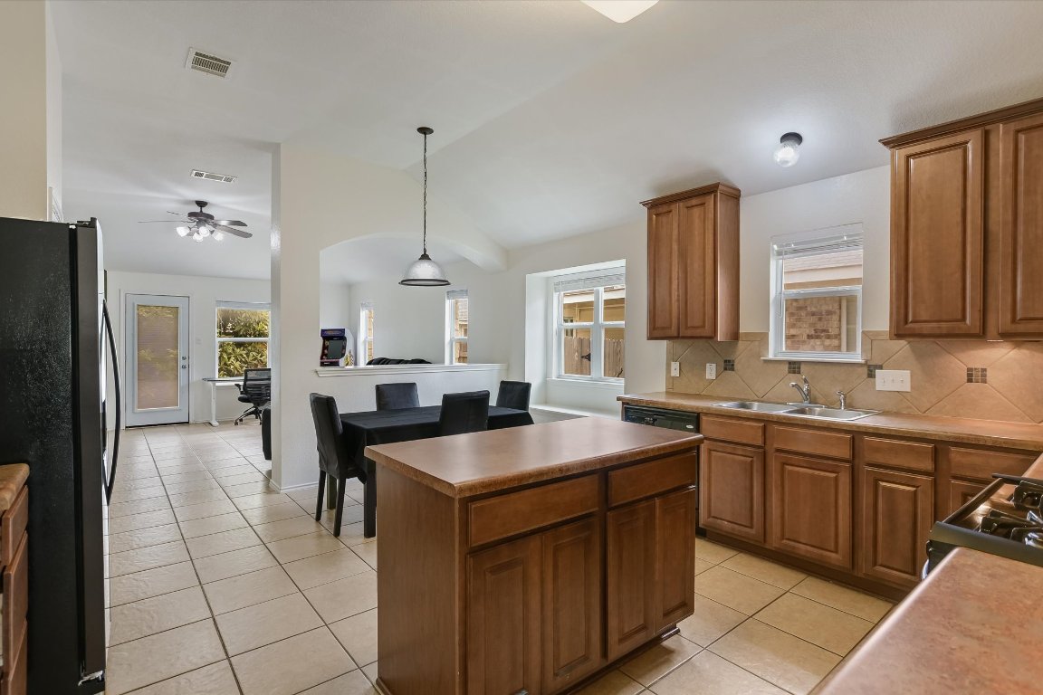 1901 Rachel Lane Round Rock, TX 78664 - Photo 21 of 35 Kitchen with vaulted ceiling, visible vents, light tile patterned floors, a sink, and freestanding refrigerator