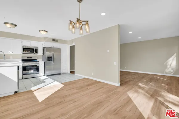 a view of empty room with wooden floor and fireplace