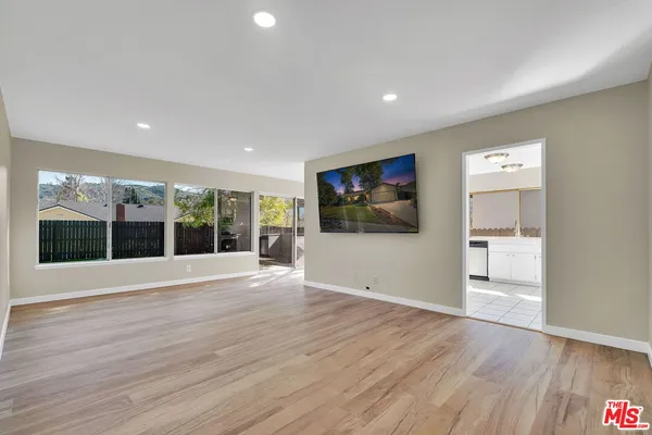 a view of a hallway with wooden floor and a living room