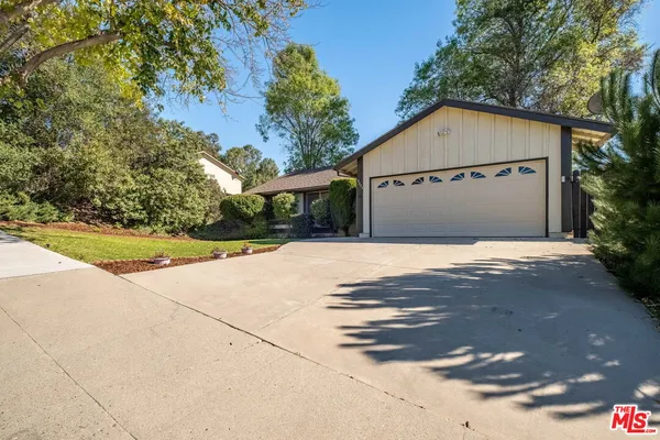 a white house with tree in front of it
