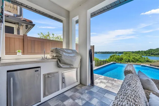 an aerial view of a house with swimming pool and lake view
