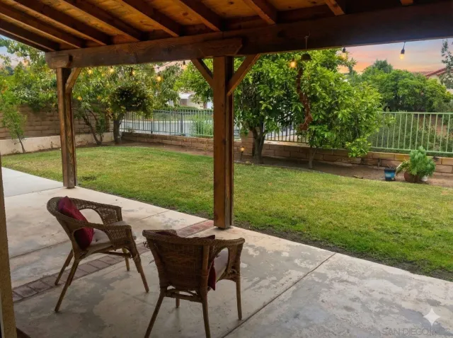 a view of a patio with a table chairs and a backyard
