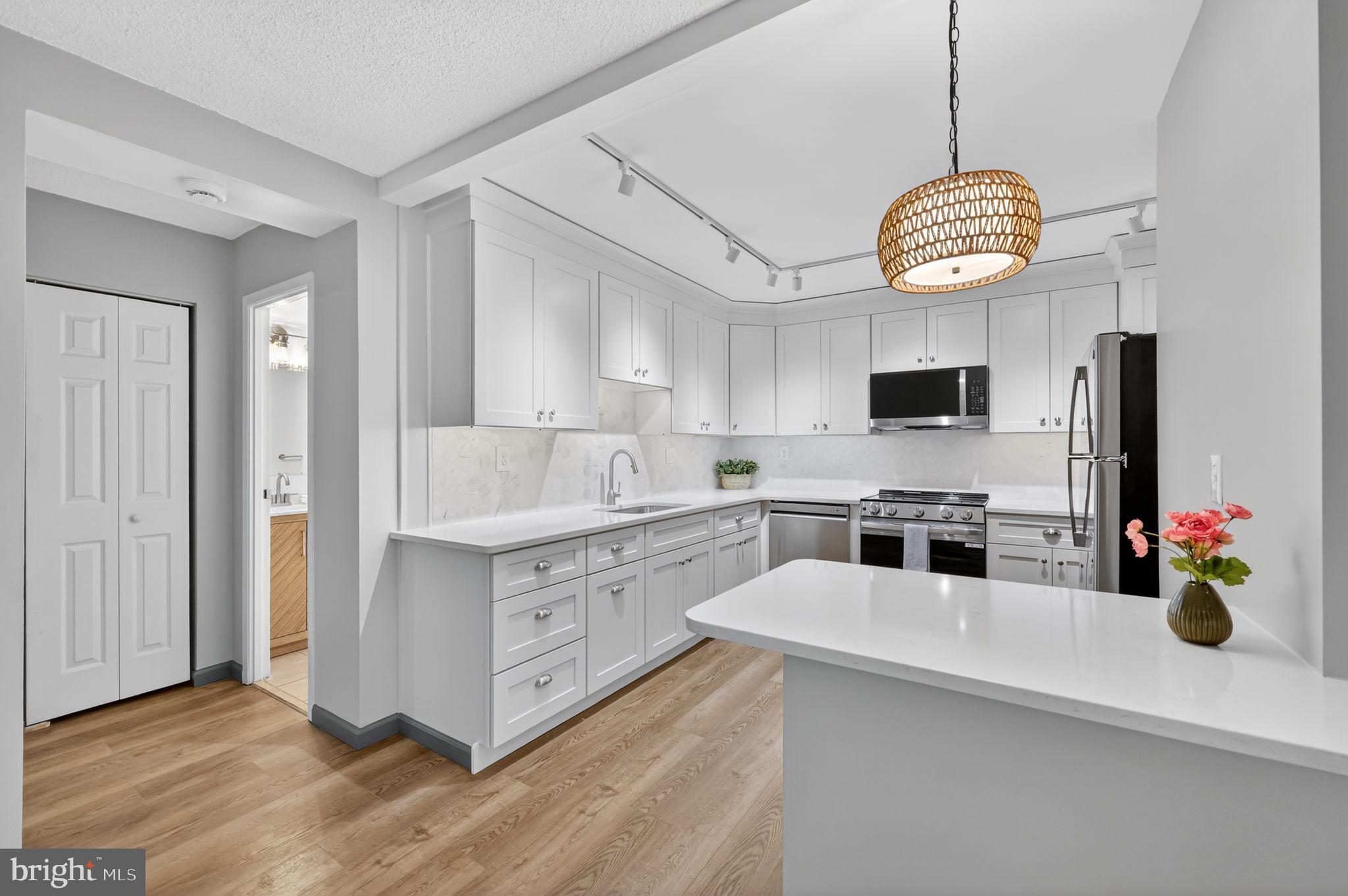 a kitchen with a white cabinets appliances and a window