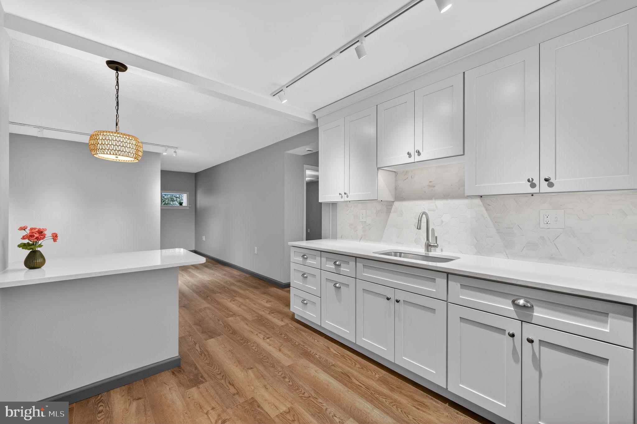 400 Glendale Road, Unit G33 Havertown, PA 19083 - Photo 2 of 26 a kitchen with a sink dishwasher and white cabinets with wooden floor